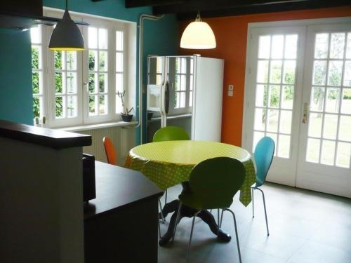 une cuisine avec une table et des chaises dans une pièce dans l'établissement Maison spacieuse et moderne avec jardin privatif, terrasses, cheminée et équipements complets à Renaison - FR-1-496-110, à Renaison