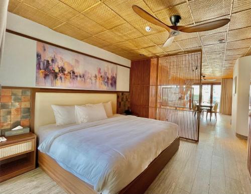 a bedroom with a large bed and a ceiling fan at LUK Inn Hotel - An Thượng, Đà Nẵng in Da Nang