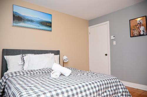 a bedroom with a bed with a black and white checkered blanket at Appartement moderne 3 chambres avec spa, jardin privé & parking gratuit - accès autonome in Saint-Jean-sur-Richelieu