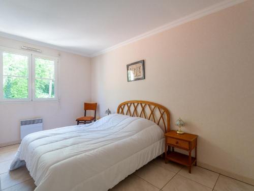 une chambre avec un lit blanc et une chaise dans l'établissement Appartement T3 au Centre d'Arcachon, avec Parking, proche Parc Mauresque et Plage, Terrasse, 2 Chambres - FR-1-319-61, à Arcachon