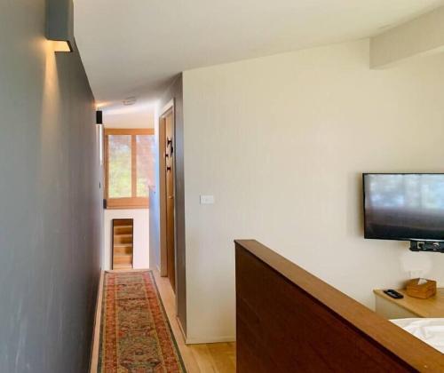 a room with a tv on a wall with a rug at One Hundred Banksias in Culburra Beach