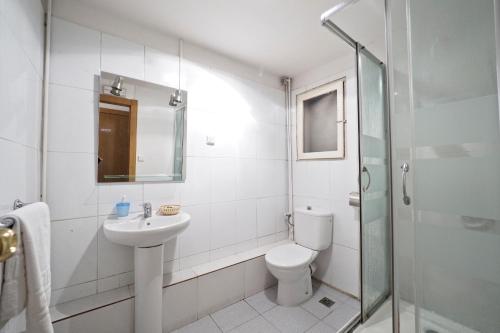 La salle de bains est pourvue de toilettes, d'un lavabo et d'une douche. dans l'établissement Hostal Elkano, à Barcelone
