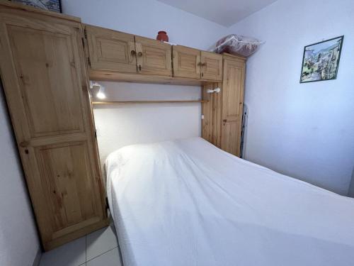 - une petite chambre avec un lit et une armoire en bois dans l'établissement BANYULS-SUR-MER : T2, loggia et parking à 2 pas de la plage - FR-1-309-39, à Banyuls-sur-Mer