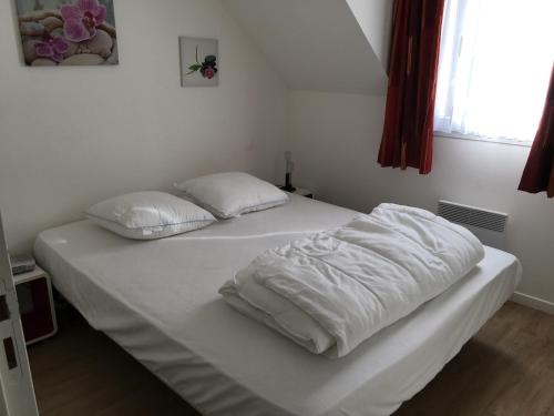 a white bed with white sheets and pillows on it at Pavillon charmant entre Baie d'Authie et plage, 3 chambres, jardinet, cœur de Fort-Mahon-Plage - FR-1-482-40 in Fort-Mahon-Plage