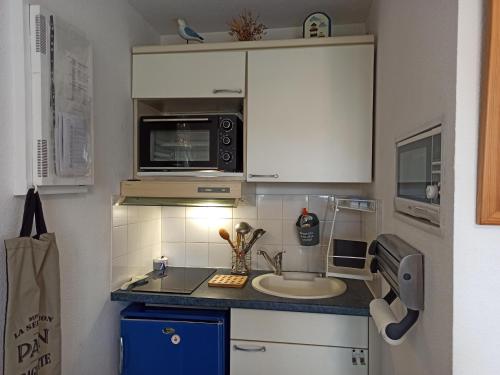 une petite cuisine avec un évier et un micro-ondes dans l'établissement T2 aux Sables d'Olonne avec Terrasse, près de la Plage - FR-1-325-132, à Les Sables-dʼOlonne