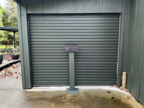 a closed garage door with a sign on it at K2 Lodge in Whangarei