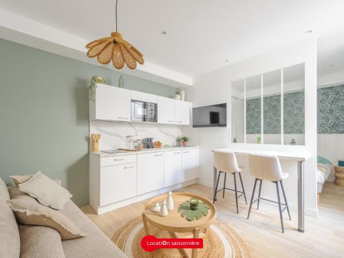 une cuisine et un salon avec un canapé et une table dans l'établissement Studio rénové et stylé, Centre La Rochelle, pour 2 avec Wifi - FR-1-535-66, à La Rochelle