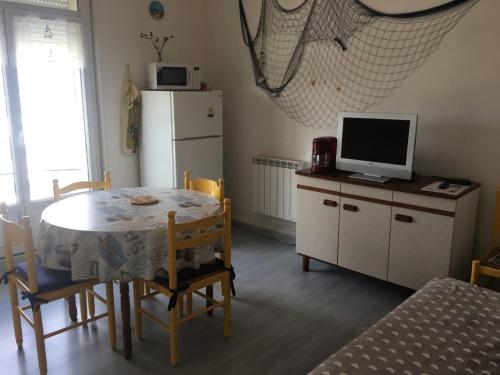 une salle à manger avec une table et un réfrigérateur dans l'établissement Appartement Coquet au Centre de Fort-Mahon-Plage, 10 min de la Plage - FR-1-482-69, à Fort-Mahon-Plage