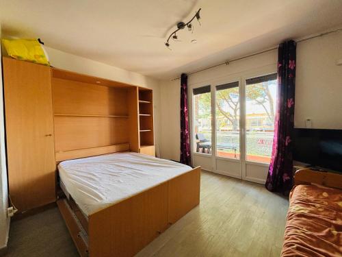 une chambre avec un lit et une grande fenêtre dans l'établissement Argelès-sur-Mer: Studio 2 pers, Terrasse, Proche Plage - FR-1-309-508, à Argelès-sur-Mer