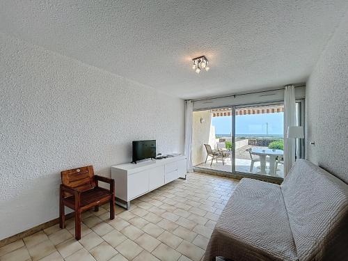 un salon avec une télévision et un canapé dans l'établissement Appartement 2P Cabine sur Plage avec Parking et Climatisation - FR-1-715-46, à Palavas-les-Flots