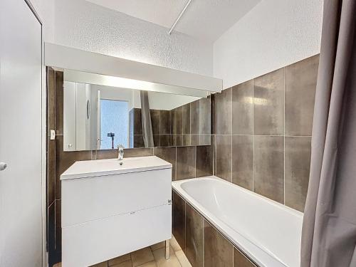 une salle de bain avec un lavabo, une baignoire et un miroir dans l'établissement Appartement 2P Cabine sur Plage avec Parking et Climatisation - FR-1-715-46, à Palavas-les-Flots