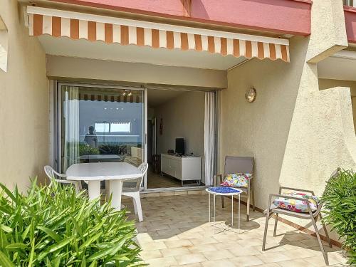 un patio avec une table et des chaises sur un patio dans l'établissement Appartement 2P Cabine sur Plage avec Parking et Climatisation - FR-1-715-46, à Palavas-les-Flots