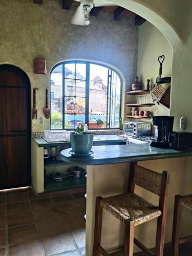 a kitchen with a large counter with a window at Botanical Studios Sayulita in Sayulita