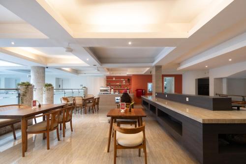 a restaurant with tables and chairs and a bar at Bustle Base Coliving and Coworking Space in Legian