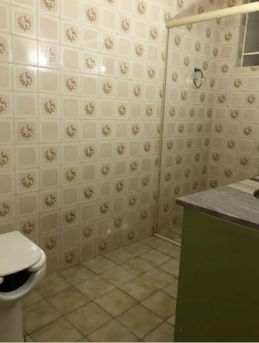 a bathroom with a toilet and a green counter at Apart 202 - Centro Histórico in Itu