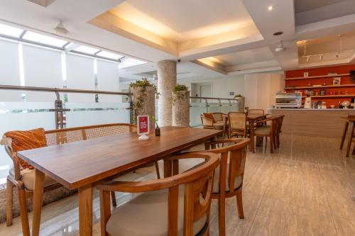 a restaurant with a wooden table and chairs at Bustle Base Coliving and Coworking Space in Legian