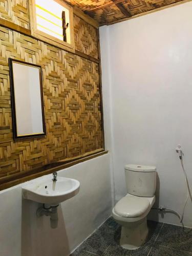 a bathroom with a toilet and a sink at Sea La Vie Cottage in El Nido