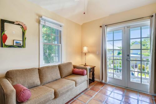 a living room with a couch and a sliding glass door at Cottage by the Pool by AvantStay w Balcony BBQ Shared Pool Month Long Stays Only in Stock Island
