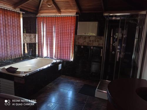 a large bathroom with a tub and a shower at Casa Nova Hotel campestre in Circasia