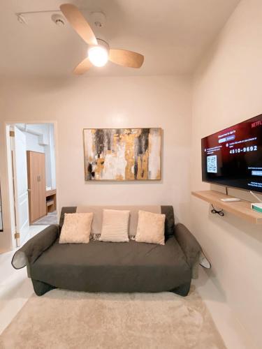 a living room with a couch and a flat screen tv at Seaview Condo in Royal Oceancrest Panglao in Dauis