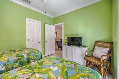 a bedroom with green walls and a bed and a television at Coral Palm by AvantStay Key West Walkable Gated Community Shared Pool in Stock Island