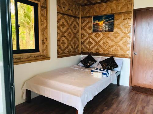 a bedroom with a white bed in a room at Sea La Vie Cottage in El Nido