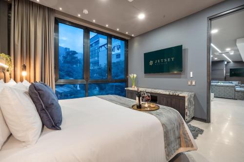 a bedroom with a large bed and a large window at Europa Suites Medellin in Medellín
