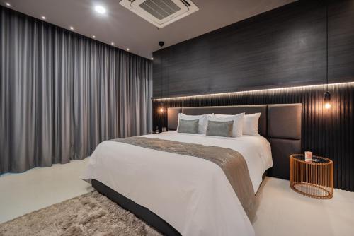 a bedroom with a large bed with a black wall at Europa Suites Medellin in Medellín