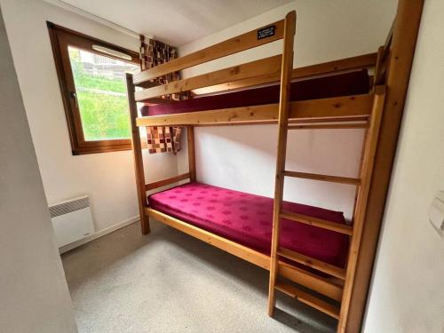 Ce lit superposé se trouve dans une petite chambre dotée d'une fenêtre. dans l'établissement Charmant appartement familial avec balcon, parking inclus - FR-1-593-132, aux Angles