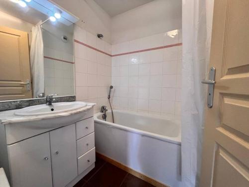 une salle de bain avec une baignoire et un lavabo et une baignoire dans l'établissement Charmant appartement familial avec balcon, parking inclus - FR-1-593-132, aux Angles