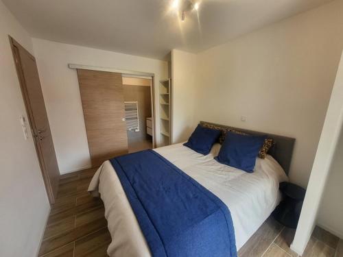 une chambre avec un grand lit avec des oreillers bleus dans l'établissement Spacieux appartement 3 chambres, terrasse et jardin à Montgenèvre - FR-1-266-250, à Montgenèvre