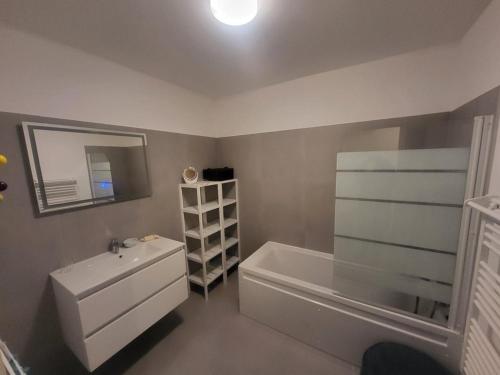 une salle de bain avec une baignoire, un lavabo et un miroir dans l'établissement Spacieux appartement 3 chambres, terrasse et jardin à Montgenèvre - FR-1-266-250, à Montgenèvre