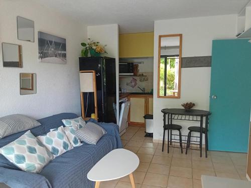 un salon avec un canapé bleu et une table dans l'établissement Appartement 4 pers à Seignosse Penon avec terrasse - FR-1-239-1127, à Seignosse