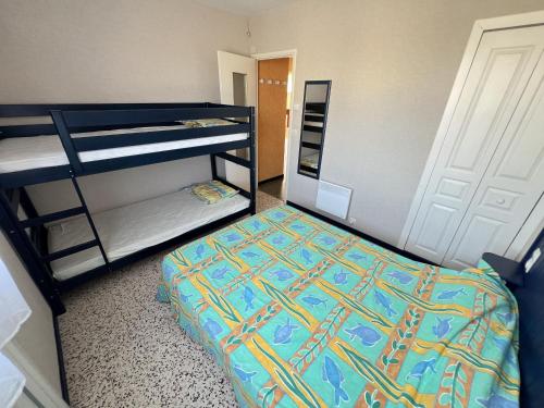 une chambre avec deux lits superposés dans une pièce dans l'établissement Appartement spacieux à Valras-Plage, accès direct à la plage, jusqu'à 6 personnes - FR-1-781-101, à Valras-Plage