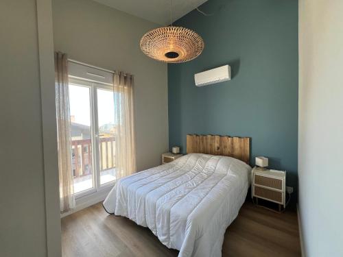 une chambre avec un lit et une grande fenêtre dans l'établissement Seignosse : Appartement rénové à pied des plages avec climatisation - FR-1-239-1126, à Seignosse