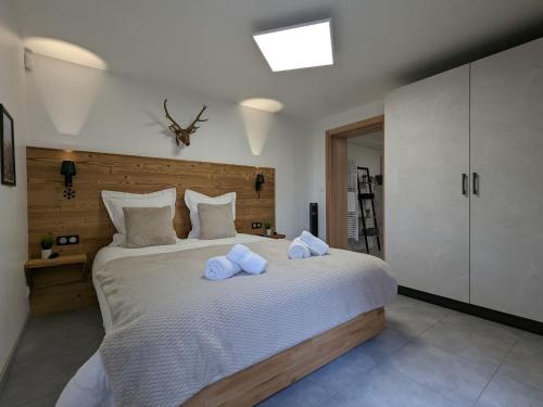 une chambre avec un grand lit avec des serviettes dessus dans l'établissement Appartement familial proche lac et centre à Gérardmer - 4 pers, animaux admis - FR-1-589-818, à Gérardmer