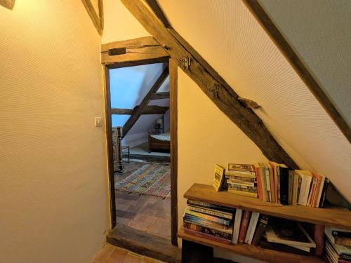 a mirror in a room with a shelf of books at Manoir du 15ème siècle avec piscine dans le Parc Naturel Régional de la Brenne - FR-1-591-740 in Mauvières