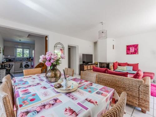 une salle à manger avec une table avec un vase de fleurs dans l'établissement Maison 6 Pers - Jardin Clos - Quartier Résidentiel - FR-1-521-259, à Biscarrosse