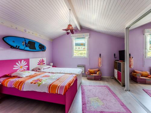 - une chambre avec un lit et une planche de surf sur le mur dans l'établissement Maison 6 Pers - Jardin Clos - Quartier Résidentiel - FR-1-521-259, à Biscarrosse