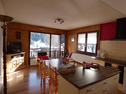 une cuisine avec une table et des chaises dans une pièce dans l'établissement Appartement lumineux 64m², 6 personnes, vue sur montagnes - FR-1-458-230, au Grand-Bornand