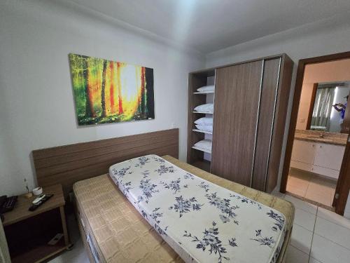 a bedroom with a bed and a painting on the wall at Apartamentos em Rio Quente com maravilhosa área de lazer e excelente localização in Rio Quente