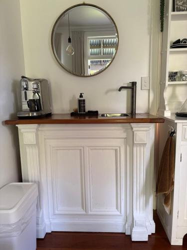 a bathroom counter with a sink and a mirror at The Wash-House historic Cottage Close to Hobbiton in Matamata