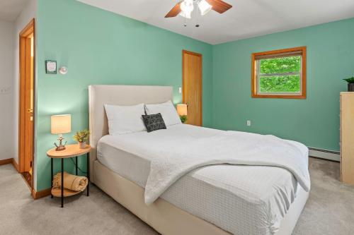 a bedroom with a bed and a blue wall at Tawny and Peaceful Game Room Firepit PatioDeck Workspace in Arrowhead Lake