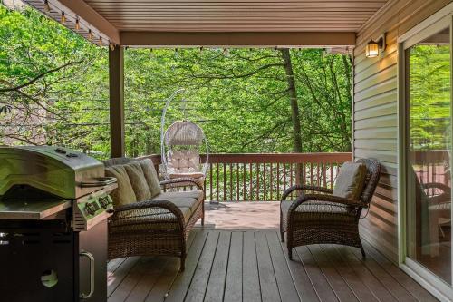 a screened in porch with a grill and chairs on it at Tawny and Peaceful Game Room Firepit PatioDeck Workspace in Arrowhead Lake
