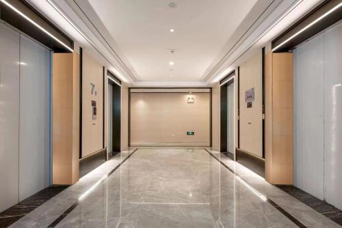 a hallway of a building with a large door at 深圳华尔曼欢朋酒店公寓 罗湖水贝珠 宝城店 in Shenzhen