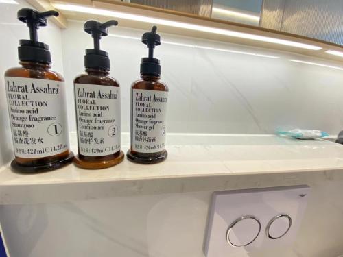 three bottles of moisturizers sitting on a shelf at 深圳华尔曼欢朋酒店公寓 罗湖水贝珠 宝城店 in Shenzhen