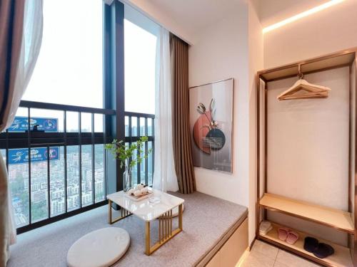 a living room with a balcony with a table at 深圳华尔曼欢朋酒店公寓 罗湖水贝珠 宝城店 in Shenzhen