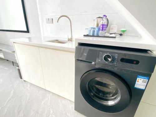a washing machine in a kitchen with a sink at 深圳华尔曼欢朋酒店公寓 罗湖水贝珠 宝城店 in Shenzhen