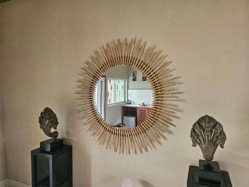 a mirror on a wall with two vases in a room at Villa Minou Ta khmau in Phnom Penh