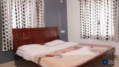 a bed with a wooden headboard in a bedroom at Maria villa in Ooty